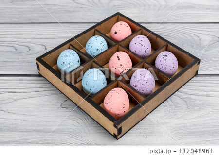Colorful Easter eggs in a box on the wooden background 112048961