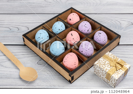 Colorful Easter eggs in a box and a gift box on the wooden background 112048964