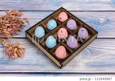 Colorful Easter eggs in a box on the wooden background 112048967