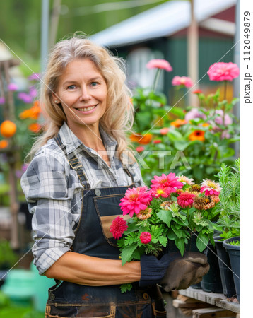 Young woman gardening in greenhouse.She selecting flowers. 112049879