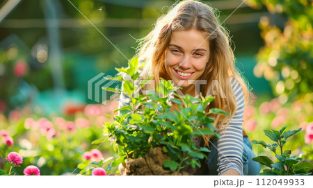 Young woman gardening in greenhouse.She selecting flowers. 112049933