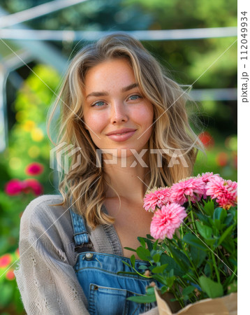 Young woman gardening in greenhouse.She selecting flowers. 112049934