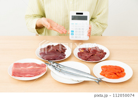 ビタミンB群を多く含む食品と電卓を持つミドル女性 ビタミンB群を多く含む食品と電卓を持つミドル女性 112050074