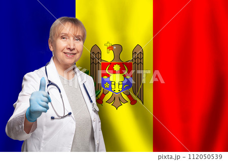 Moldovan smiling mature doctor woman holding stethoscope on flag of Moldova background 112050539