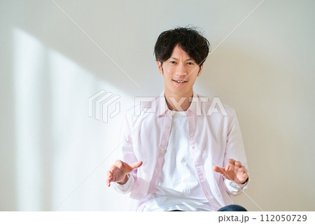 両手を広げて、驚いている若い男性 両手を広げて、驚いている若い男性 112050729