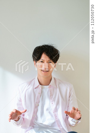 両手を広げて、驚いている若い男性 112050730