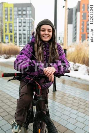 European stylish woman in an informal look rides a bicycle on the street 112051041