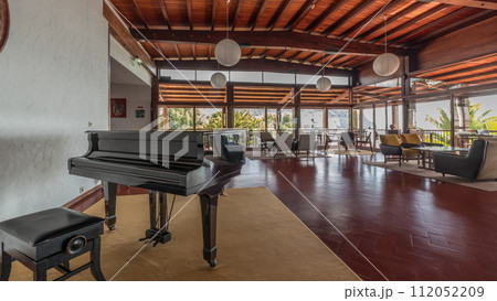 Panorama showing Interior of a modern hotel cafe bar restaurant with piano and fireplace timelapse 112052209