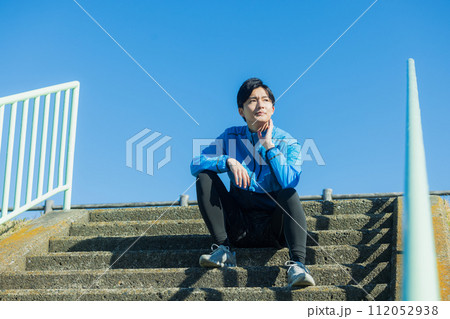 河川敷をランニングする若い男性 112052938