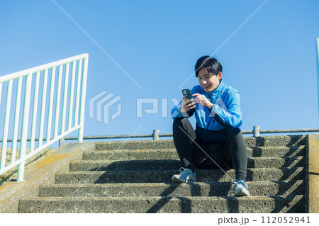河川敷をランニングする若い男性 112052941