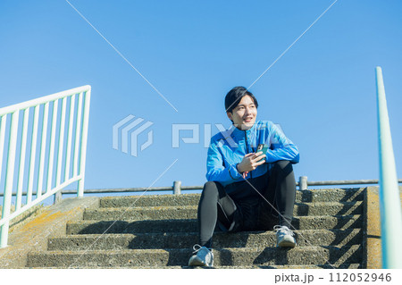 河川敷をランニングする若い男性 112052946