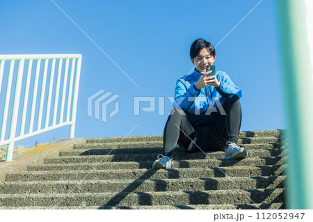 河川敷をランニングする若い男性 112052947