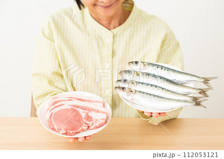 肉と魚を持つ女性 112053121