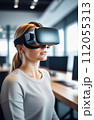 Portrait of young European woman wearing virtual reality glasses in office interior. 112055313