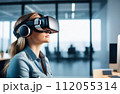 Portrait of young European woman wearing virtual reality glasses in office interior. 112055314