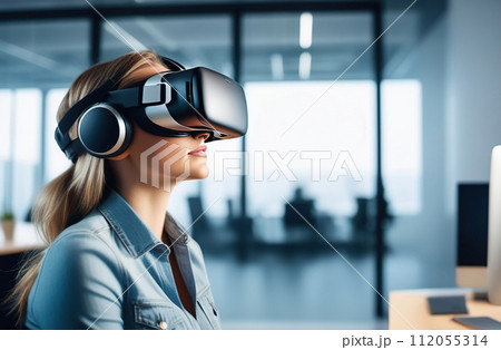 Portrait of young European woman wearing virtual reality glasses in office interior. 112055314