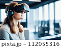 Portrait of young European woman wearing virtual reality glasses in office interior. 112055316