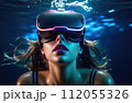 Young woman wearing virtual reality glasses under the water. Concept of dive into the Metaverse. 112055326