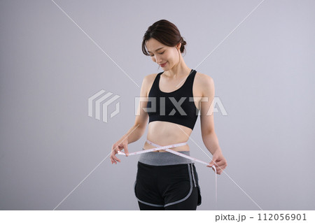 メジャーでウエストを測るミドル女性 メジャーでウエストを測るミドル女性 112056901