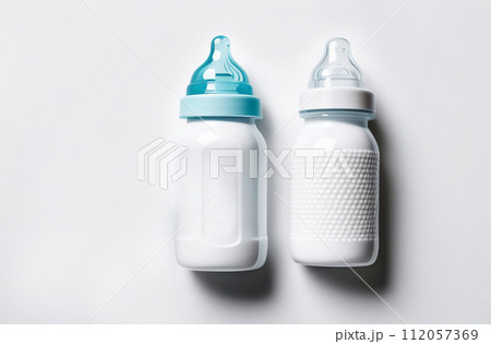 Flat lay with baby supplies, booties and toys on white color. Newborn background. Feeding bottle. Infant, kids banner, blank space for text. Baby goods, stuff and accessories. Children care. Top view 112057369
