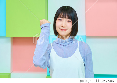 ガッツポーズをする若い女性とカラフルな背景 112057503