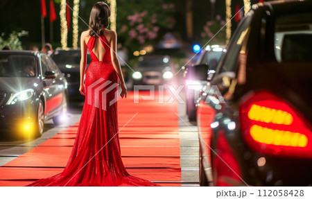 Celebrity woman in long fashionable luxury gown walking on a red carpet to celebrity gala event Celebrity woman in long fashionable luxury gown walking on a red carpet to celebrity gala event 112058428