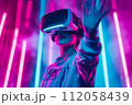 Video gaming player in VR headset playing virtual reality games in 3D VR equipment 112058439