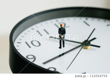 時計の上で考えるビジネスマンの人形 112058759