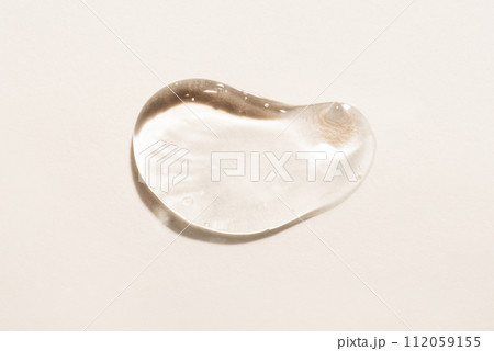 Transparent hyaluronic acid gel drop on a beige background. 112059155