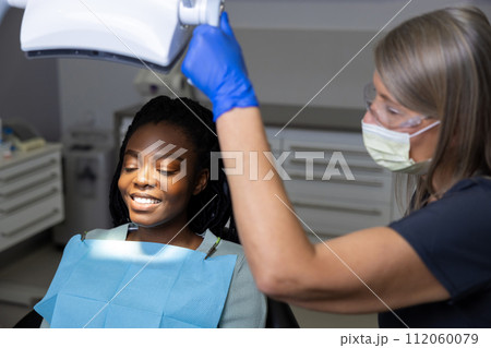 Multicultural lady in dental clinic doing teeth checkup Multicultural lady in dental clinic doing teeth checkup 112060079