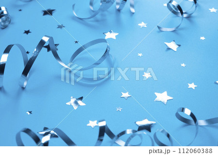 Festive blue background with silver serpentine and confetti stars, boy or newborn birthday concept. High quality photo Festive blue background with silver serpentine and confetti stars, boy or newborn birthday concept. High quality photo 112060388