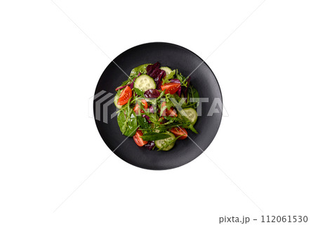 Delicious fresh salad with arugula, spinach, cucumber and cherry tomatoes in a ceramic plate Delicious fresh salad with arugula, spinach, cucumber and cherry tomatoes in a ceramic plate 112061530