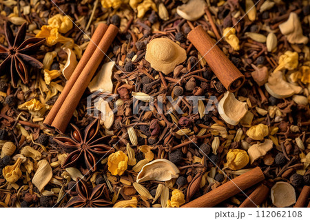 Assorted spices with cinnamon sticks, star anise, and cloves on a textured background 112062108