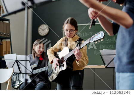 Selective focus shot of girl and her classmates playing instrumental music in classroom at school Selective focus shot of girl and her classmates playing instrumental music in classroom at school 112062245