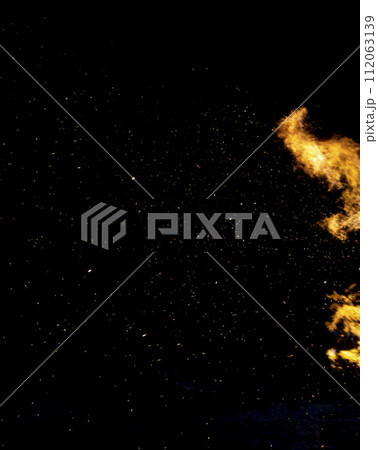 Flying sparks on the background of fire. Flames of fire with sparks in the night. Fire background. 112063139