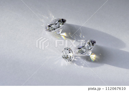 brilliant cut diamond held by tweezers on white background 112067610