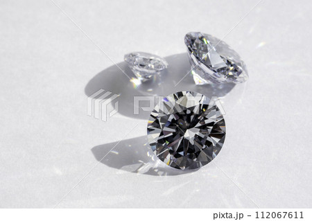 brilliant cut diamond held by tweezers on white background 112067611