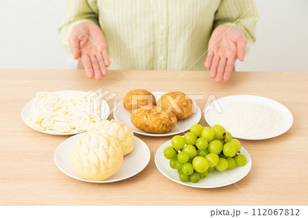 糖質を多く含む食品(炭水化物)とミドル女性 糖質を多く含む食品(炭水化物)とミドル女性 112067812