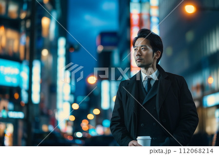 夜の街並みでコーヒーを飲むビジネスマン 夜の街並みでコーヒーを飲むビジネスマン 112068214