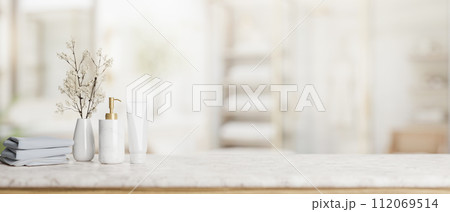 Copy space on a luxury white marble tabletop with toiletries in a modern bright and clean bathroom. Copy space on a luxury white marble tabletop with toiletries in a modern bright and clean bathroom. 112069514