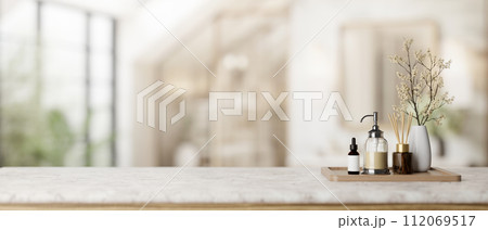 A spa set on a white marble tabletop with a blurred background of a contemporary, spacious bathroom. A spa set on a white marble tabletop with a blurred background of a contemporary, spacious bathroom. 112069517