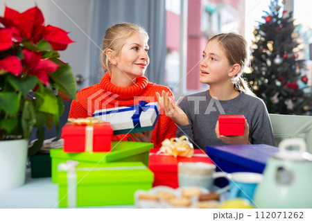 Mom and daughter unpack gifts during christmas 112071262