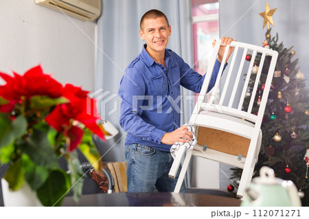 Man wiping dust from chair 112071271