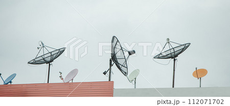 Many old communication satellite dishes expired and left on rooftops. 112071702
