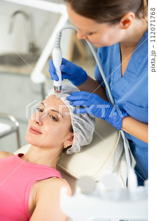 Cosmetologist makes facial gas liquid oxygen serum epidermal peeling for rejuvenation girl face skincare, anti aging cosmetic procedure in beauty spa salon. Beautician makes face skin treatment 112071768