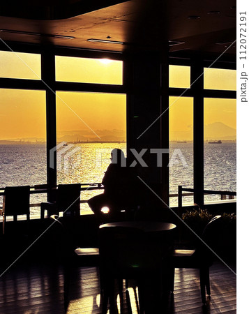 夕景を眺める人物 112072191