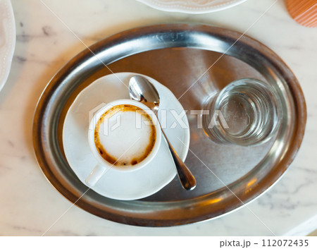 Cup of coffee served with glass of water Cup of coffee served with glass of water 112072435