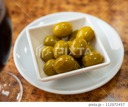 Light snack - bowl with pickled green olives 112072457