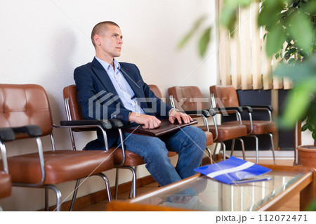 Man with briefcase waiting for job interview at office 112072471