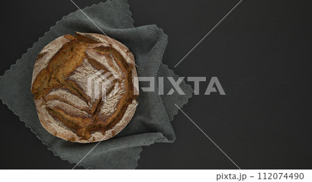 Bread loaf on a gray kitchen towel black chalkboard Bread loaf on a gray kitchen towel black chalkboard 112074490